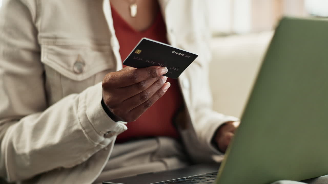 Woman using credit card for online shopping on laptop