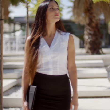 young businesswoman walking through a park