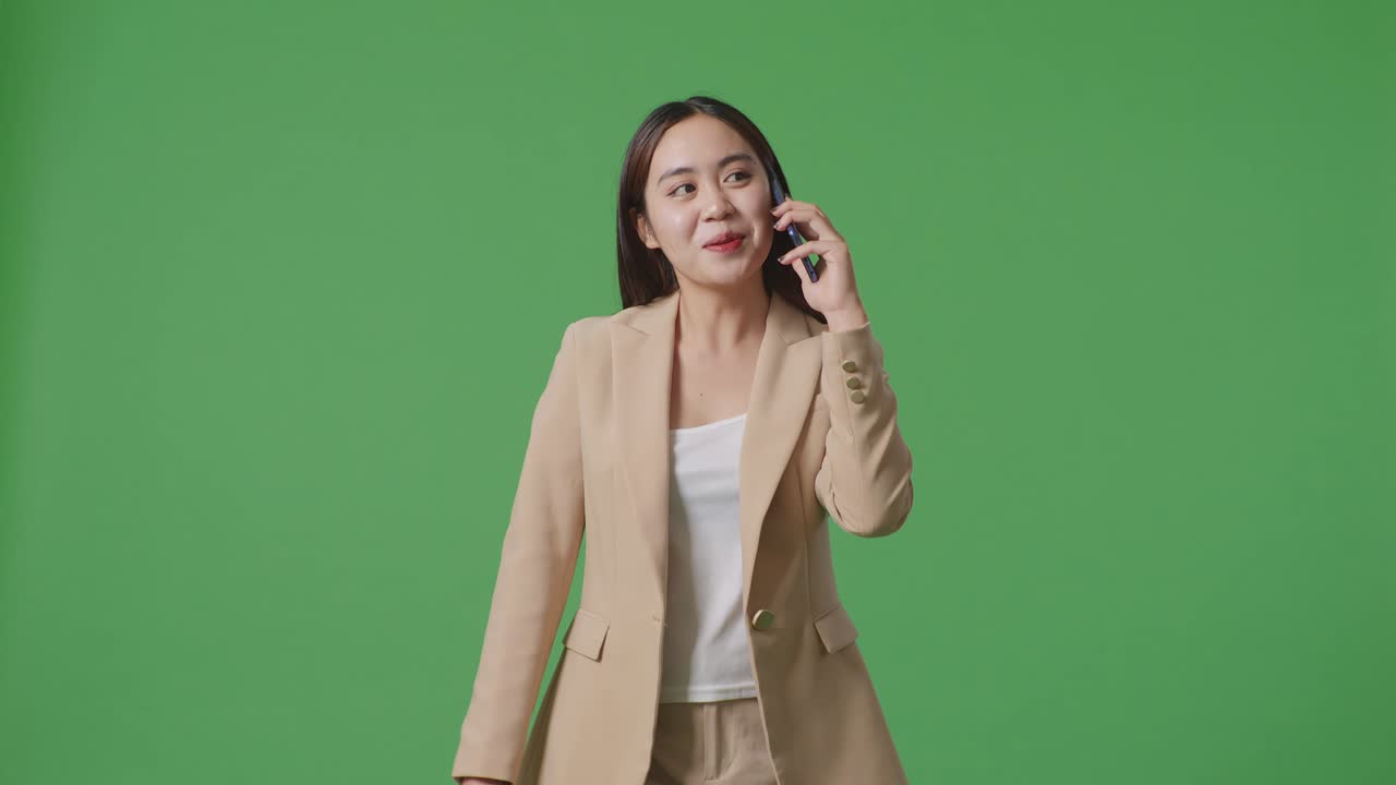 아시아 사업가 여성이 휴대 전화로 이야기하고 녹색 화면에서 고 크로마 키