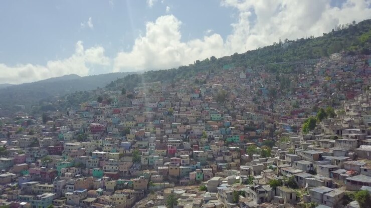Amazing aerial over the slums favela and shanty towns in the Cite Soleil district of Port Au Prince Haiti with soccer stadium foreground 1