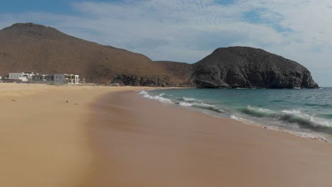 establishing shot of beach, ocean and mountains near luxury resort