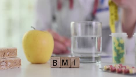 doctor's desk with bmi blocks, healthy food, and supplements, indicating a focus on health and nutrition