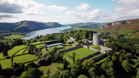 aerial view of ancient castle or abbey ruins by a lake and mountains