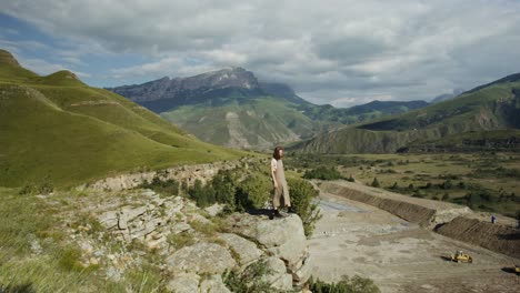 woman standing on mountain cliff