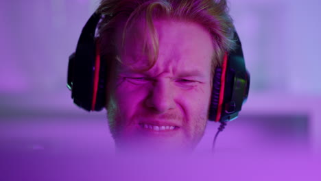 Disappointed-gamer-fail-game-in-neon-lights-closeup.-Angry-man-shout-at-computer