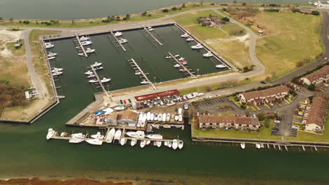 a high angle shot over a salt marsh area with a square dock in view. the camera dollys in and pans left towards the dock. it's a cloudy day and it is quiet.
