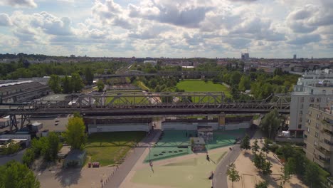 Calma-Vista-Aérea-Vuelo-Panorama-Resumen-Drone-Del-Puente-Ferroviario-De-Acero-En-El-Parque-En-Gleisdreieck-Berlín-Alemania-En-El-Día-De-Verano-De-2022