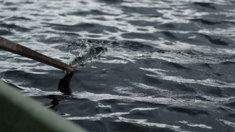 oar of a row boat hitting calm waters