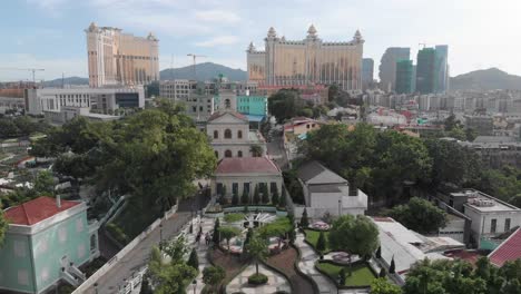 tiro revelador inclinado del horizonte de taipa en macao con el parque y la iglesia en primer plano y el hotel casino en segundo plano