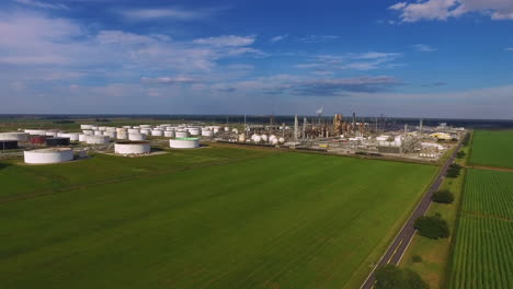 an aerial over an industrial oil refinery in an area of fields and farms