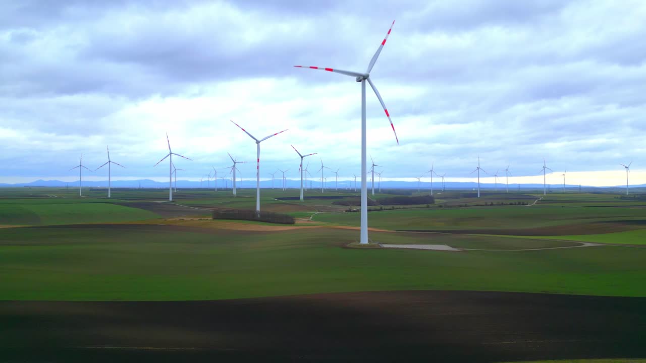 Wind Farm With Verdant Farmland During Cloudy Day. Aerial Shot