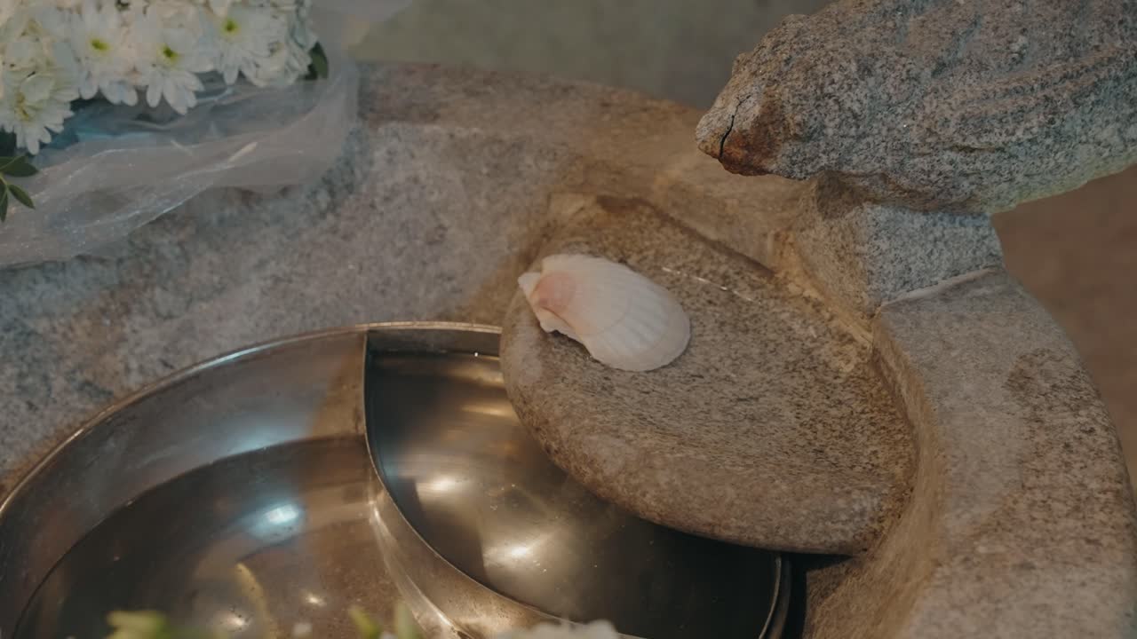 Baptismal font with water and shell