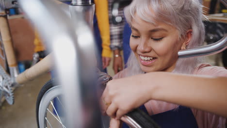 aprendices femeninas en el taller comprobando los frenos de un marco de bicicleta construido a mano