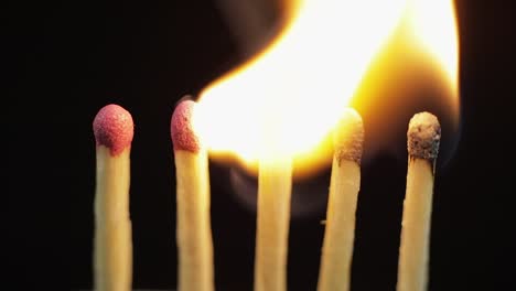 Matches-light-up-one-by-another-in-series-on-black-background