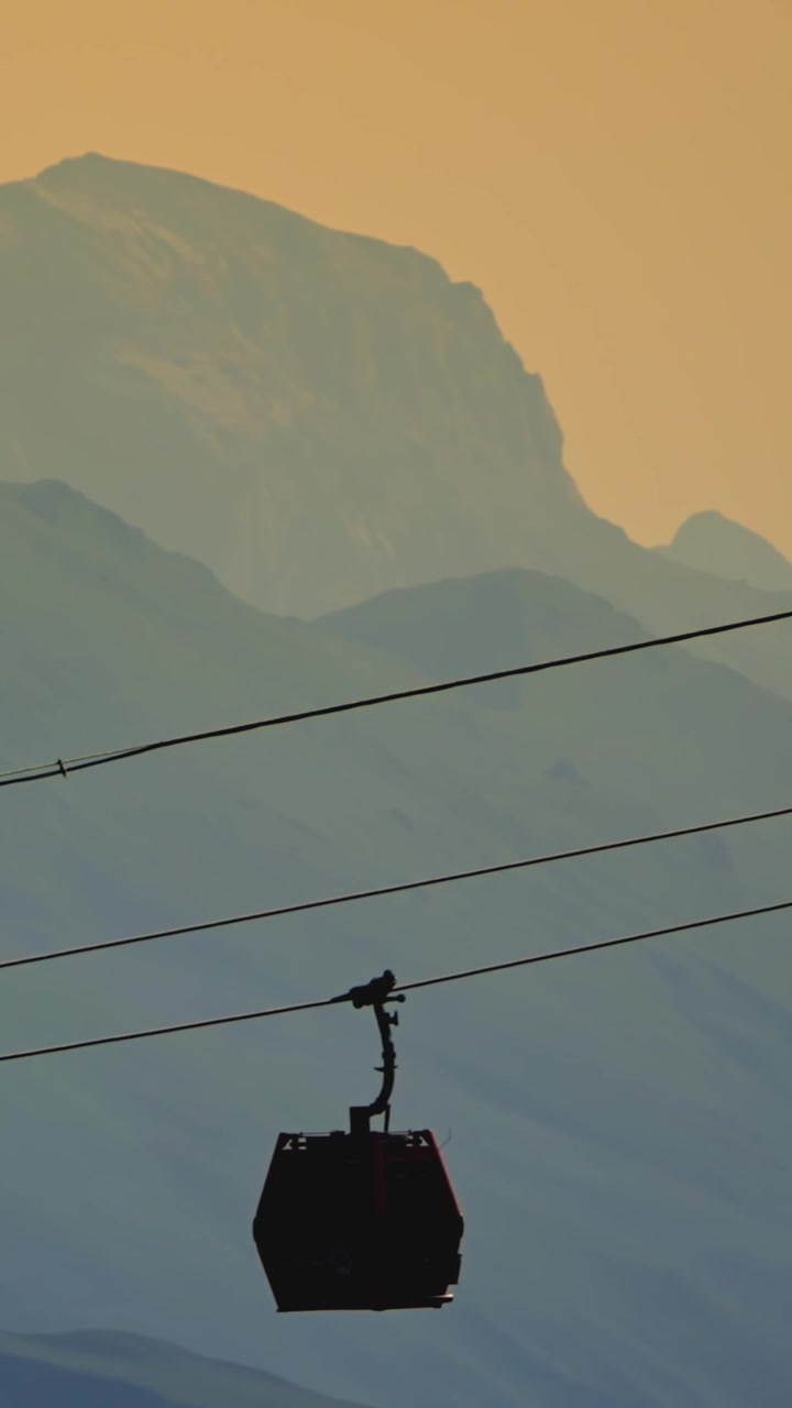 Silhouette di una Gondola Contro Montagne Nebbiose al Tramonto