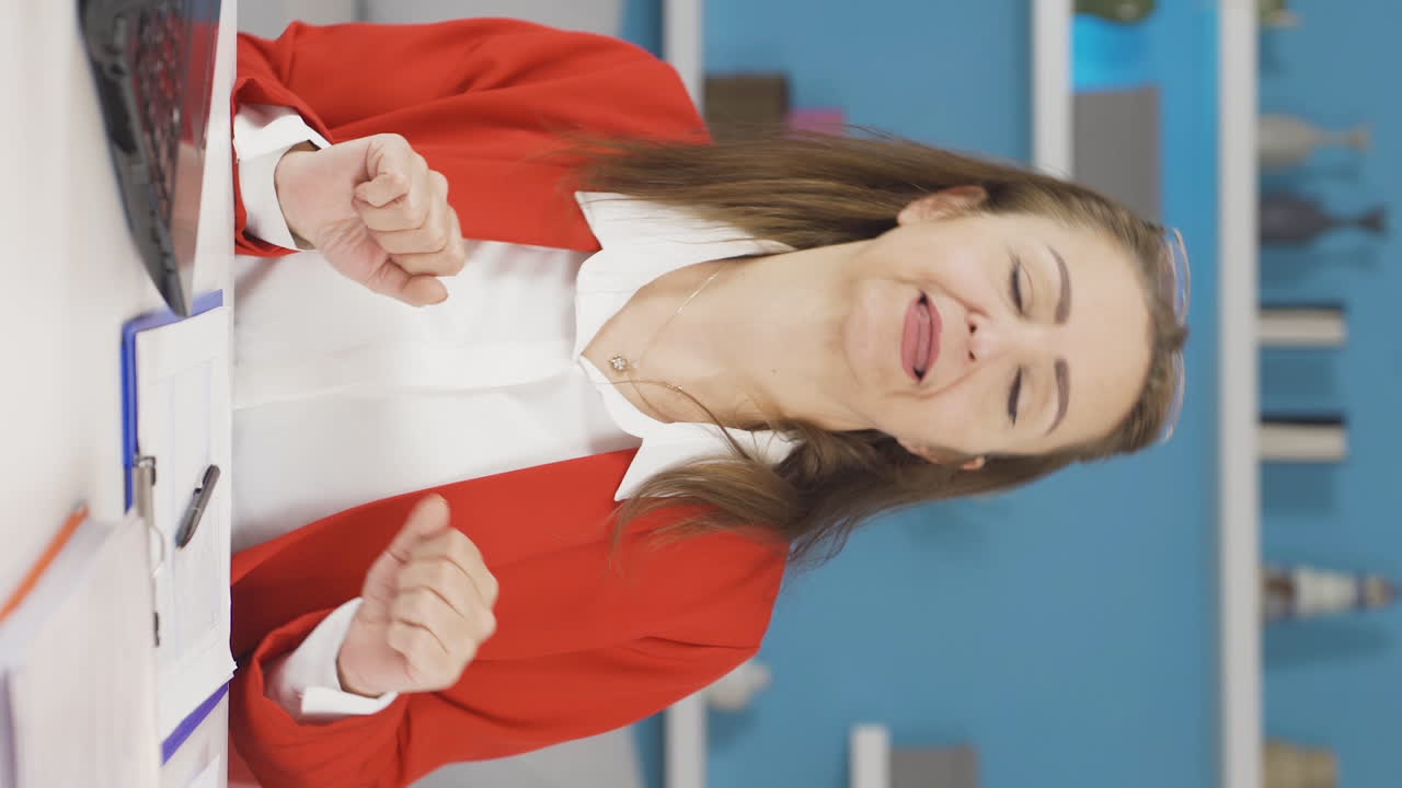 vídeo vertical de la mujer trabajadora de la oficina en casa bailando y trabajando.