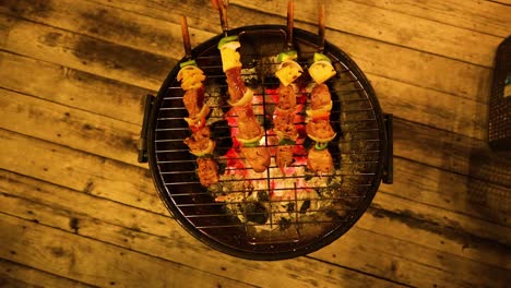 grilling meat skewers over glowing coals