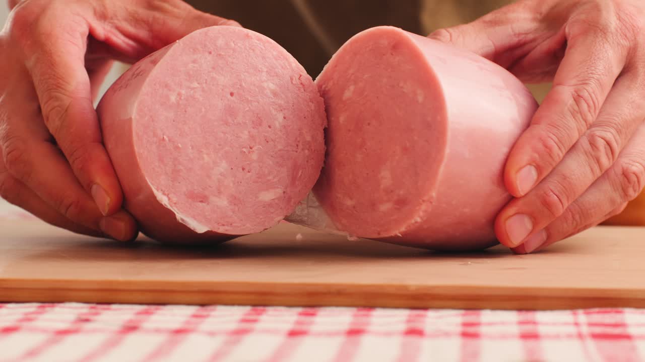 Ham italian mordatella, man Slices Of Traditional Italian antipasti mortadella sausage on a wooden cutting board, close up macro of chicken or turkey jamon, fat breakfast dish.