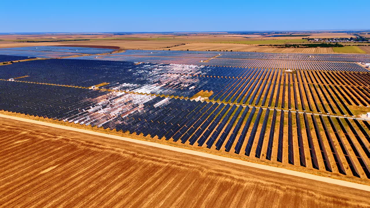 Industrial solar farm in desert region. Large-scale solar power station spreads across desert land under bright clear sky