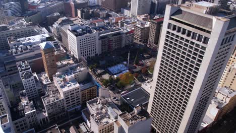 aerial view of san francisco cityscape with a skyscraper, public square, and ice rink