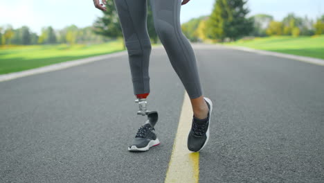 Disabled-athlete-warming-legs-before-workout-in-park.-Woman-training-outdoors