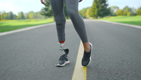 atleta discapacitado calentando las piernas antes del entrenamiento en el parque. mujer entrenando al aire libre