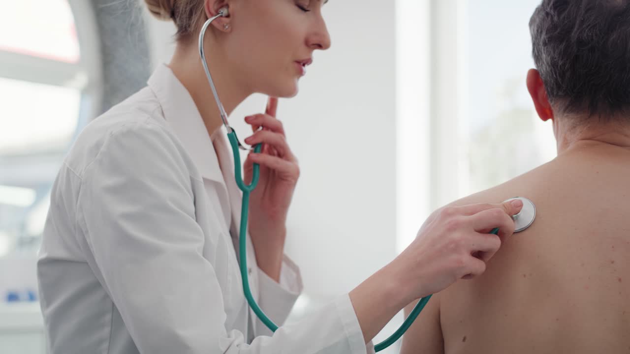 vista de la mano de una doctora examinando a un hombre mayor