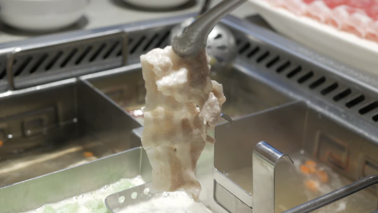 삶은 사천 전골 중국식 요리 아시아 수프에서 요리 한 돼지 고기 조각을 가져 가라.
