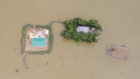 rural houses surrounded by muddy flood water, aftermath of strong typhoon. - aerial shot