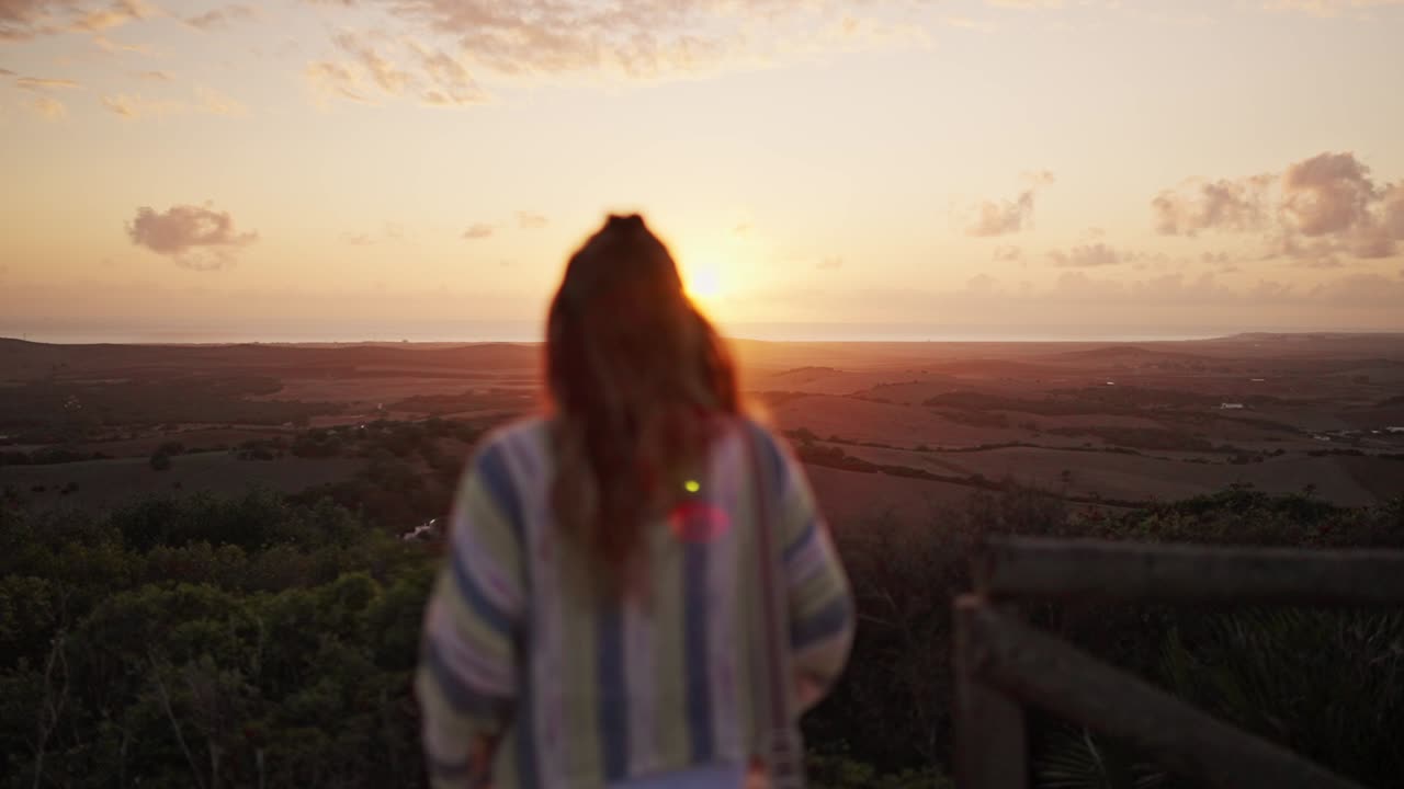 Giovane modella in posa in campagna con il tramonto sullo sfondo
