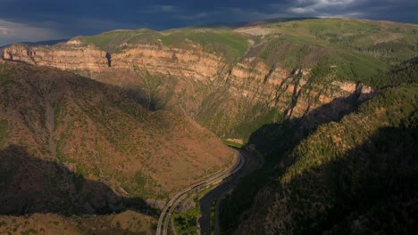 glenwood springs glenwood canyon scenic drive i70 colorado river aerial drone summer traffic sun grand mesa cliffside flat top hanging lake late afternoon dark rain thunderstorm cloudy forward pan up