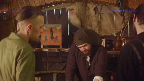 three medieval men talking in a dimly lit room