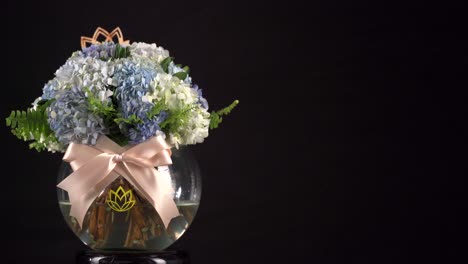 tanque de agua de clavel arreglo floral con deslizador de cinta rodada sobre fondo negro