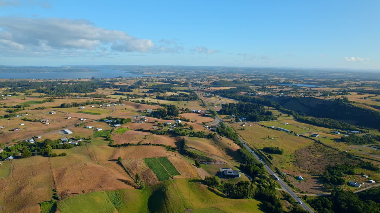 Aerial Wide view of Lemuy island, countryside scenery with green fields sprawling to the sea, Chile
