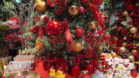 árbol de navidad decorado con bolas doradas y rojas gira en una mesa giratoria en el centro comercial, espíritus y estado de ánimo de navidad