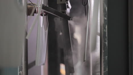 hand image of a man painting a metal parts in the paint shop