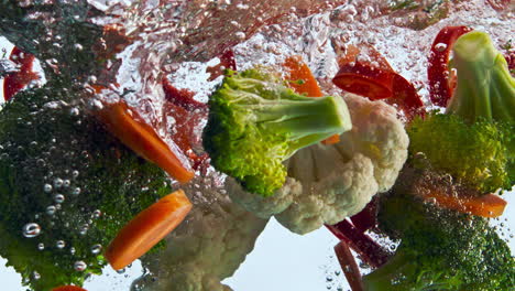 ripe vegetables splashing water in super slow motion close up. veggies floating.