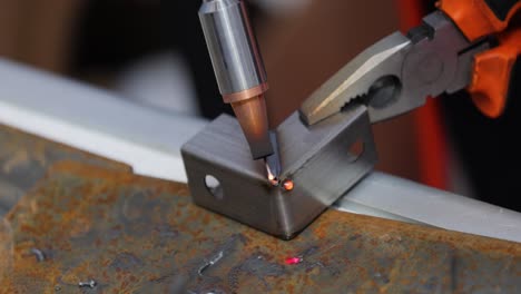 Laser-welding-machine-with-hand-hold-gun.-Laser-welding-is-shown-in-close-up.