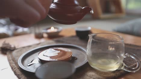 slow motion tea ceremony pouring tea into a glass pitcher