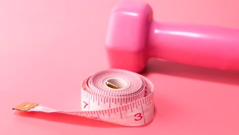 pink dumbbell and measuring tape