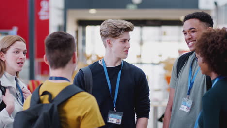 group of college student friends meeting and talking in busy communal campus building