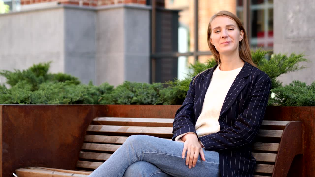 벤치에 앉아 있는 성공한 사업가 여성의 엄지손가락