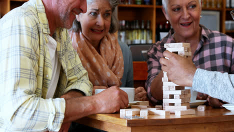 Glückliche-Freunde,-Die-Jenga-Spiel-Spielen,-Während-Sie-Eine-Tasse-Kaffee-4k-Trinken