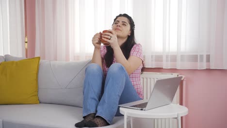 la mujer bebiendo café apoyada en el calentador tiene frío.