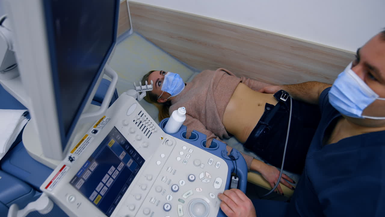 Female patient undergoing ultrasound check up of kidneys. Health examination in modern clinics. Top view.