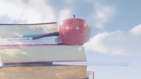 Animation-of-clouds-over-books-and-apple