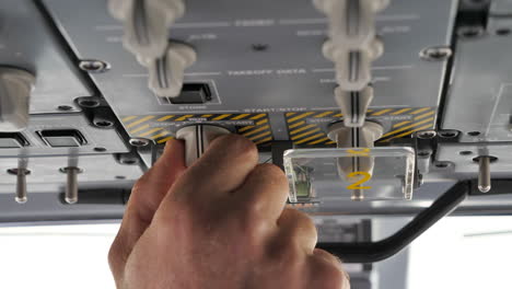 Close-Up-Of-A-Pilot's-Hand-Starting-Aircraft-Engine-By-Turning-Knob-On-The-Overhead-Panel