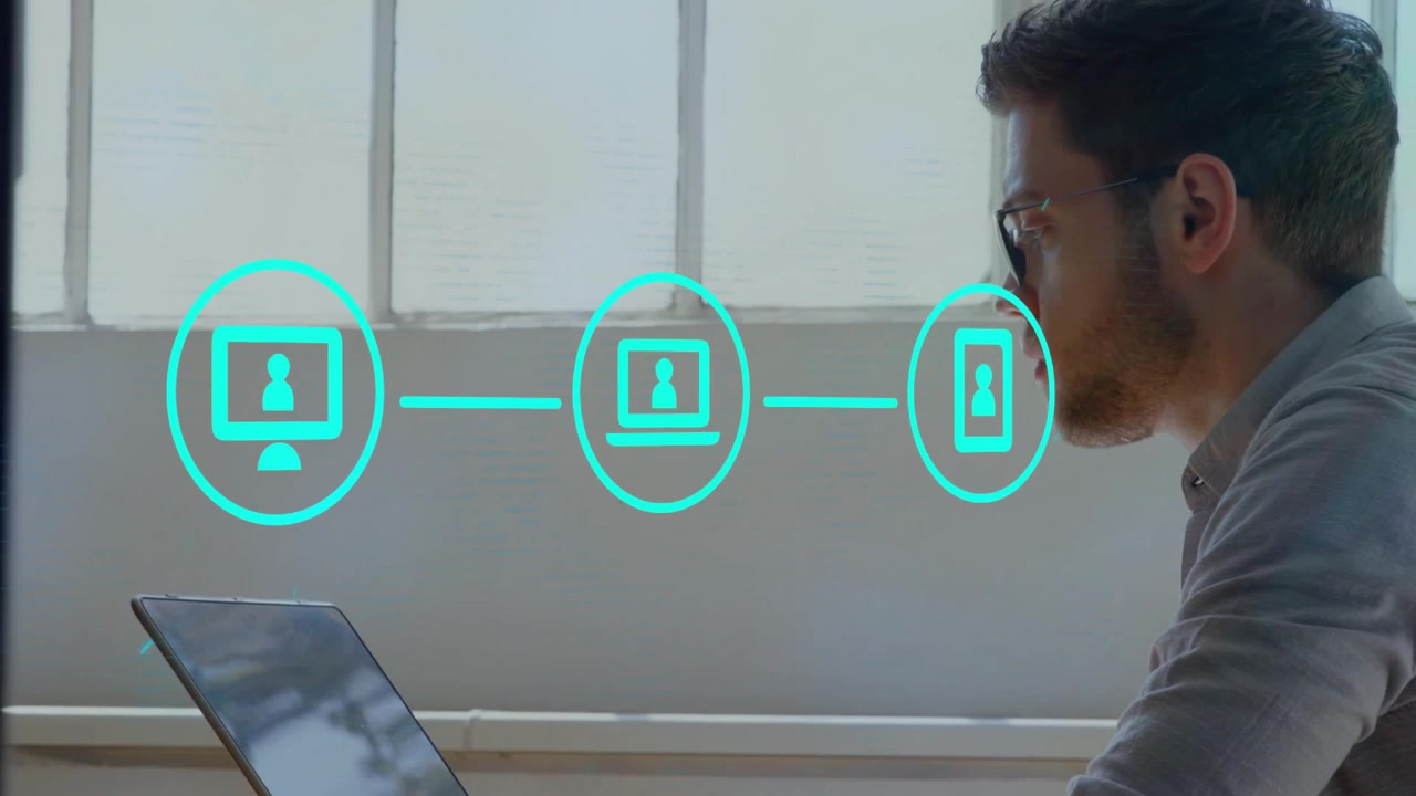 Office worker typing on laptop animating devices into user icons highlighting phone endpoint