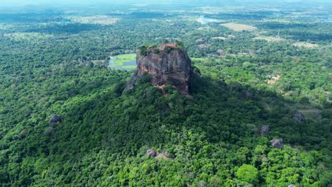 aerial drone landscape of sigiriya ancient rock formation temple ruins on top of cliff mountaintop surrounded by forest sri lanka kandy travel tourism asia