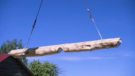 log beam being lifted by crane